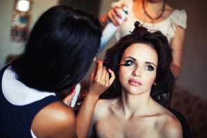 wedding. Young beautiful girl applying make-up by artist